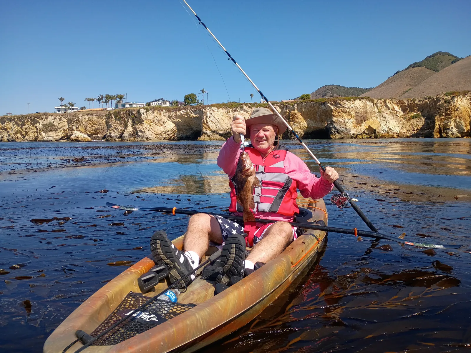 Angler holding a fresh rockfish on a kayak fishing tour